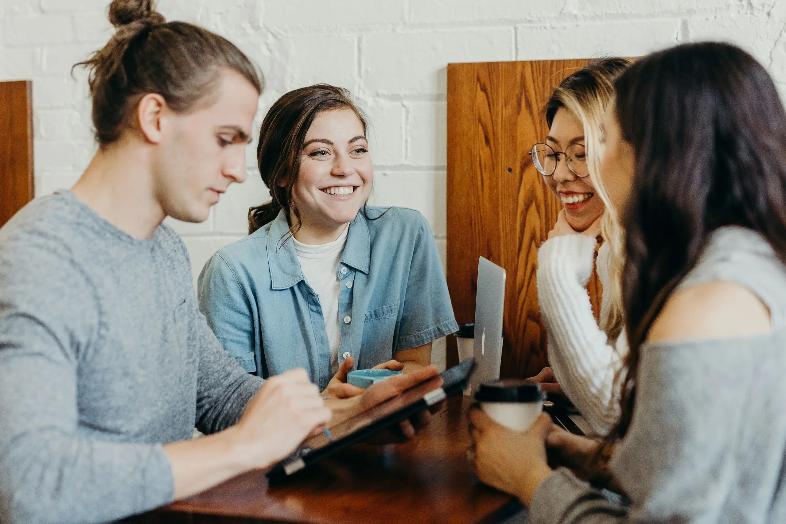 Four colleagues laughing together at a table
