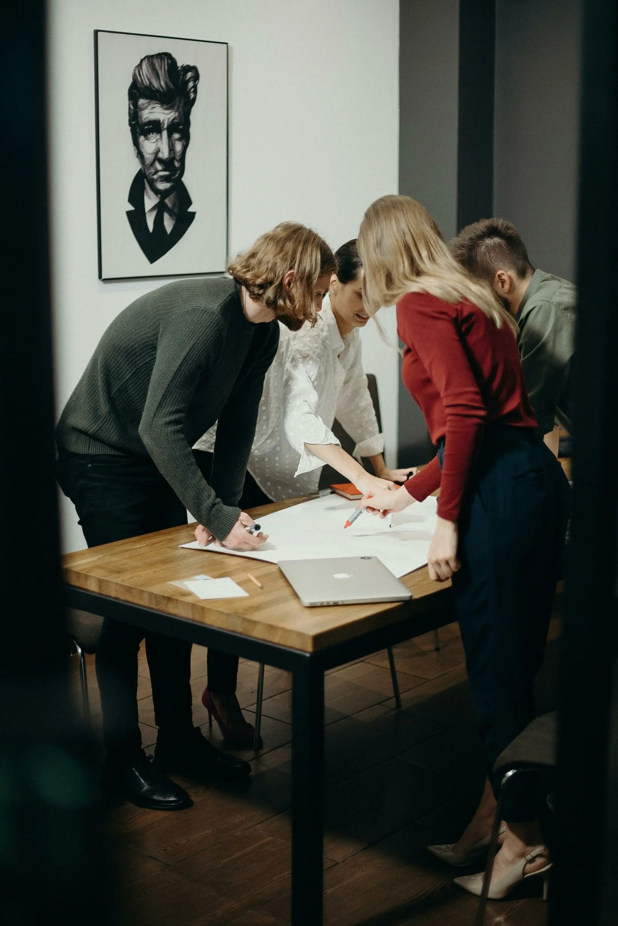 Colleagues leaning over drawings on a table