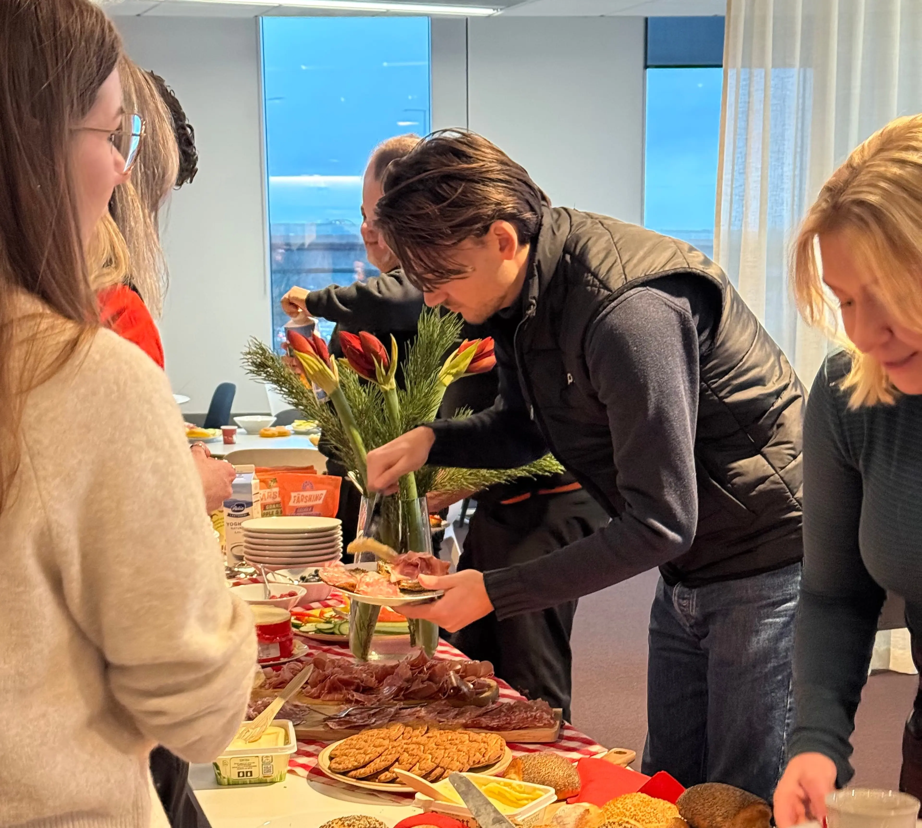 Colleagues at a breakfast table with bread and toppings at the office